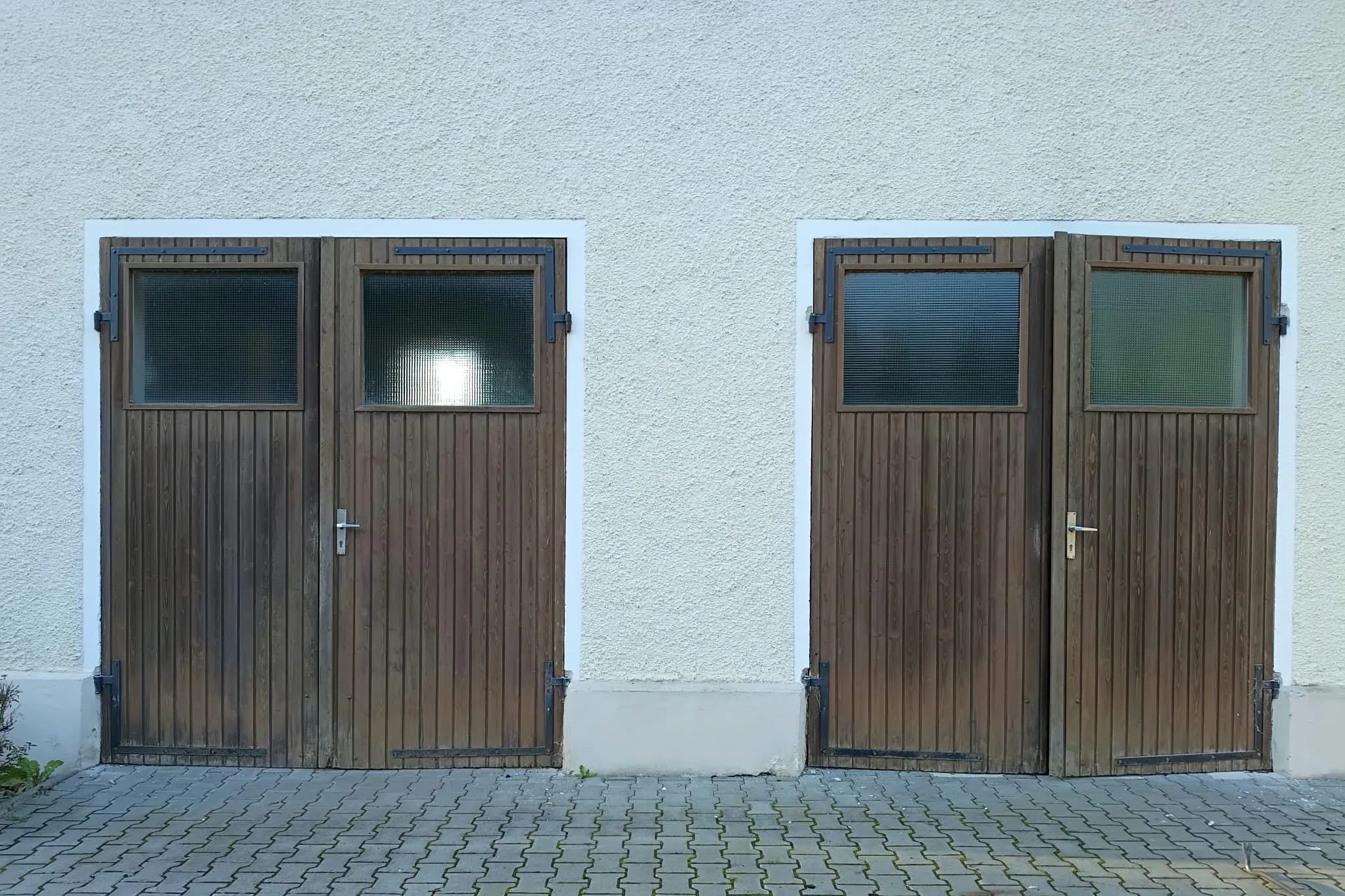Zwei alte Holztüren mit Verglasung in einer Garagenfassade in Rotthalmünster.